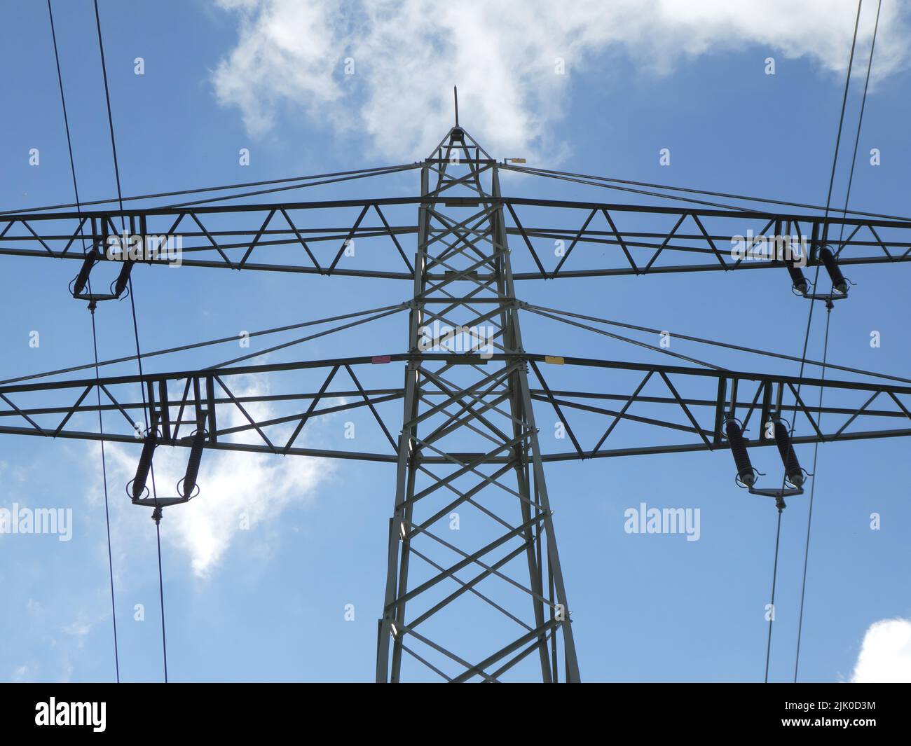 Electricity pylon against blue sky with white clouds Stock Photo - Alamy