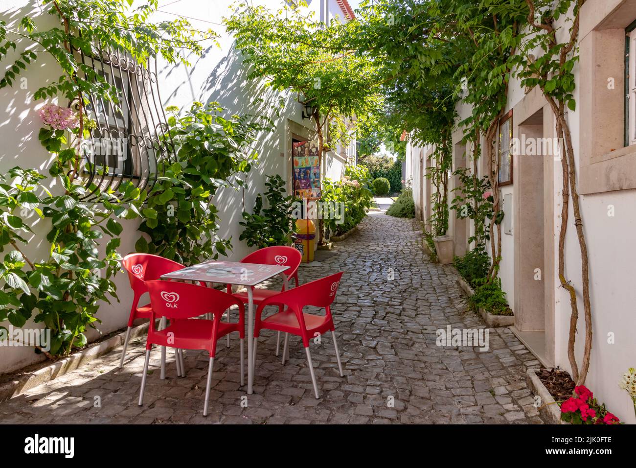Picturesque alley with chairs and a cafe in the old town of the upper town of Ourem in Portugal Stock Photo