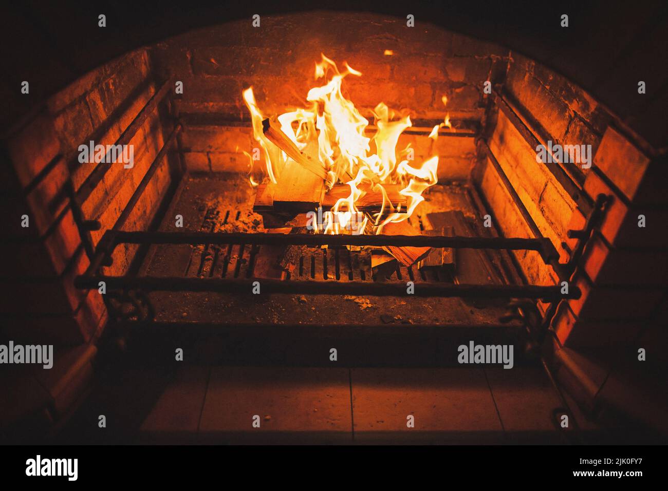 Bright fire burns in a stone fireplace. Stock Photo