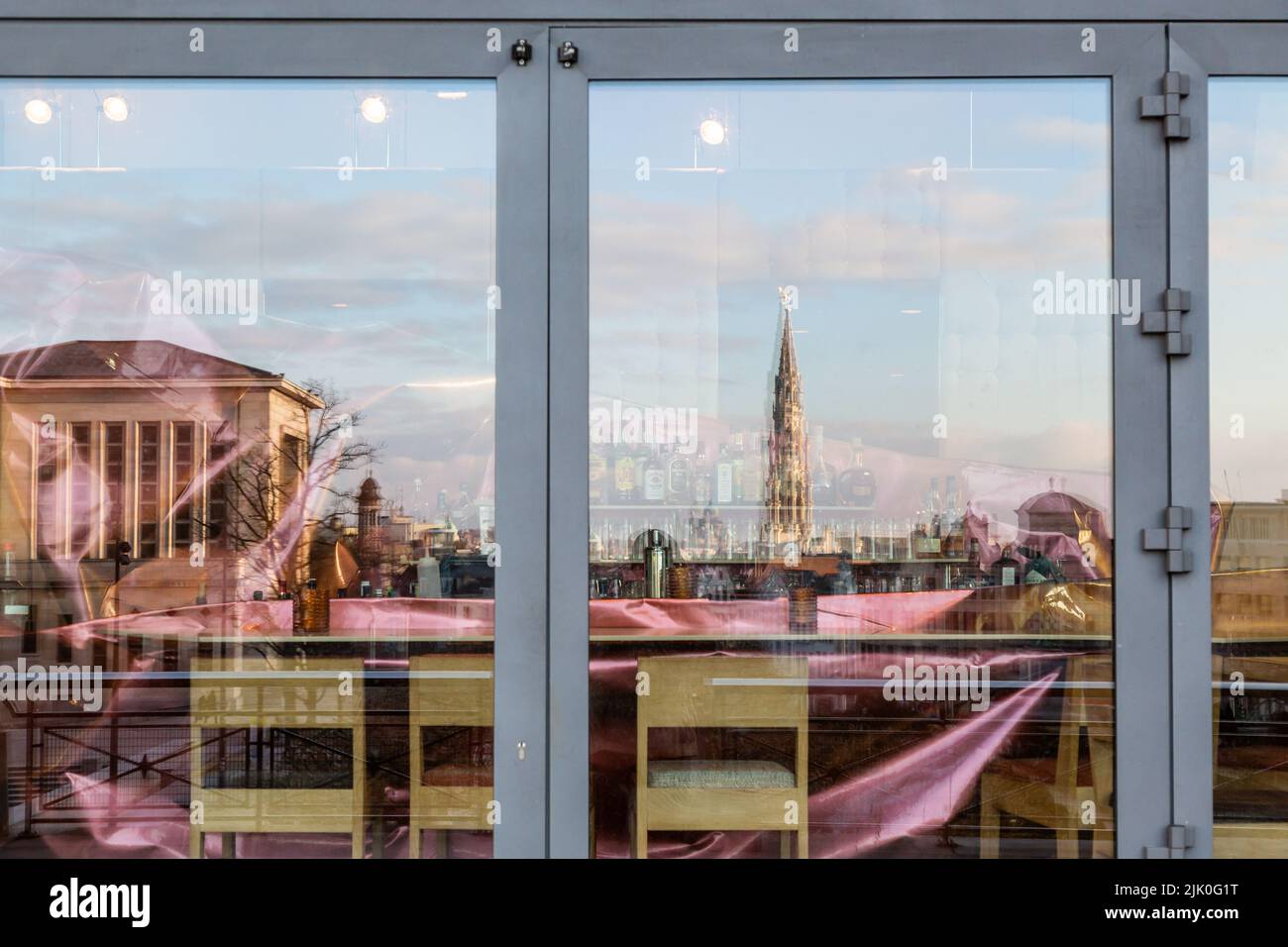 Cityscape of the center of Brussels, with the tower of the town hall, reflected in the windows of a restaurant located on the Mont des Arts. Stock Photo