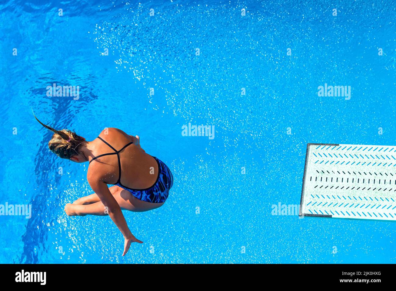 Aquatic pool diving girl  action water entry  overhead photo. Stock Photo