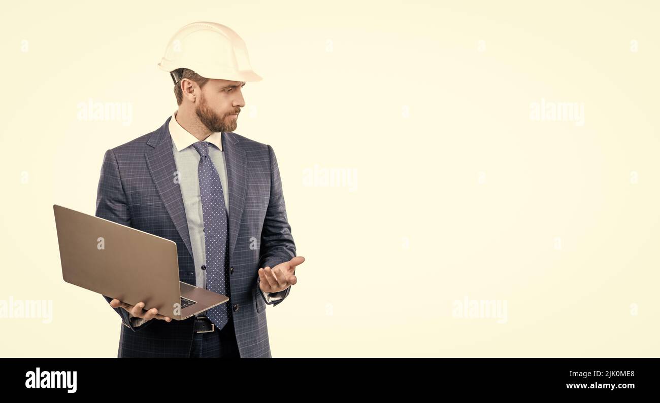 Serious engineer man in hardhat and suit use laptop computer for constructing, engineering Stock Photo