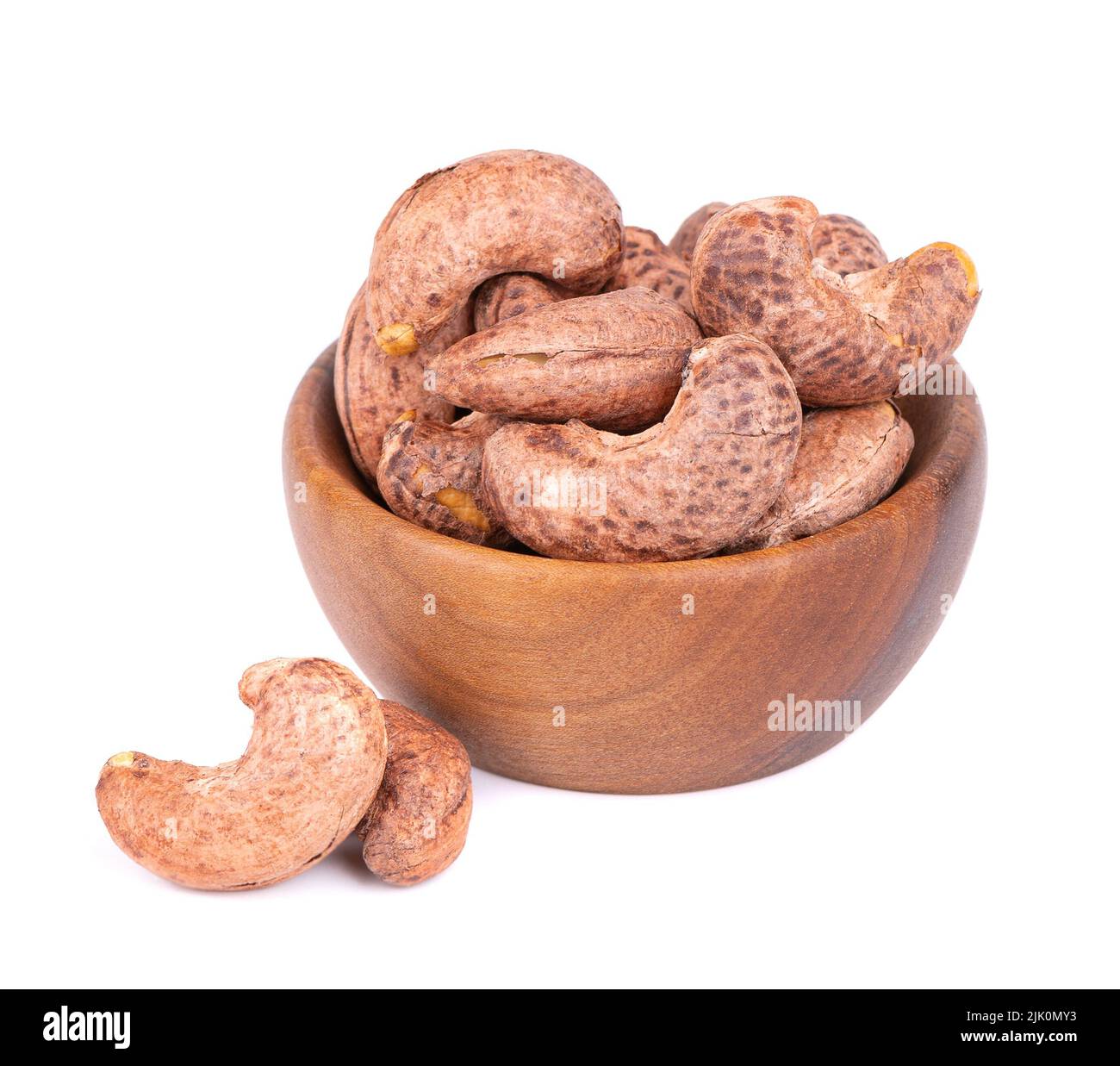 Cashew nuts in shell in wooden bowl, isolated on white background