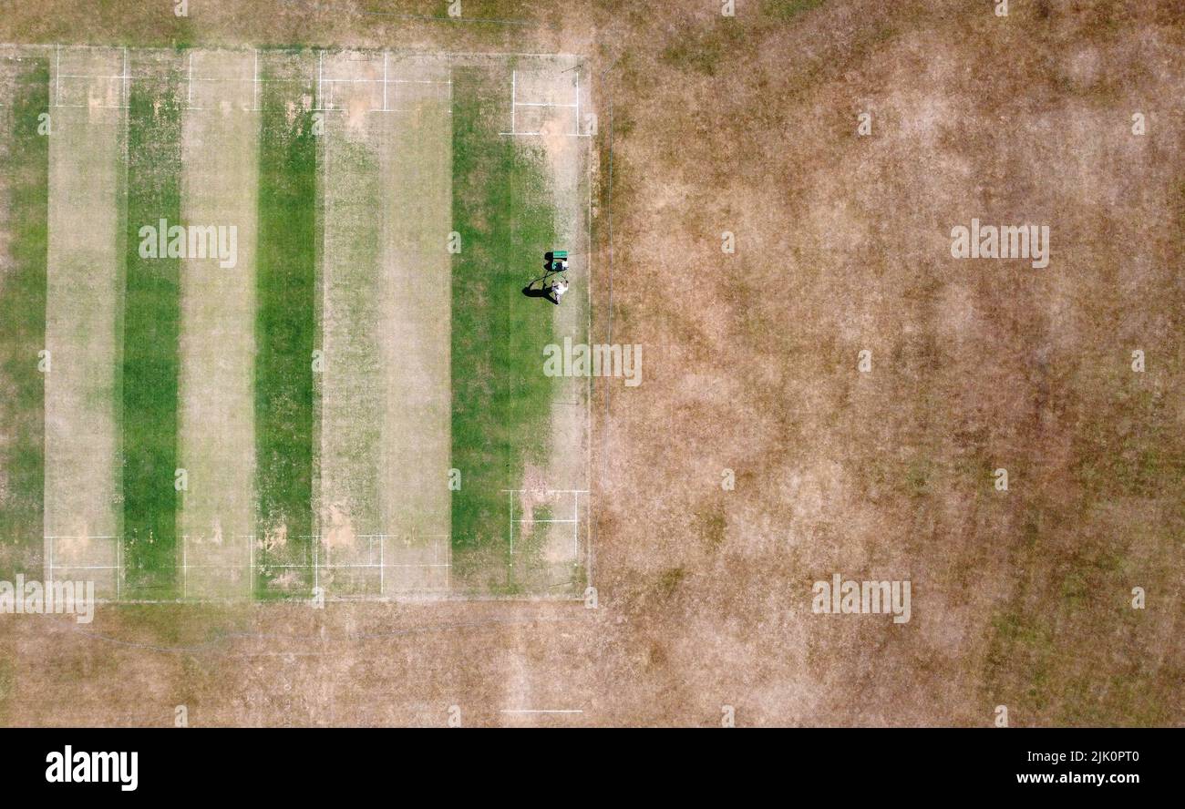 Vic Lilley, groundsman at Boughton and Eastwell Cricket Club in Ashford, Kent, prepares the wickets for matches this weekend. England faces drought in August if the hot and dry weather continues, with officials set to meet to discuss how to cope with the conditions. Picture date: Friday July 29, 2022. Stock Photo