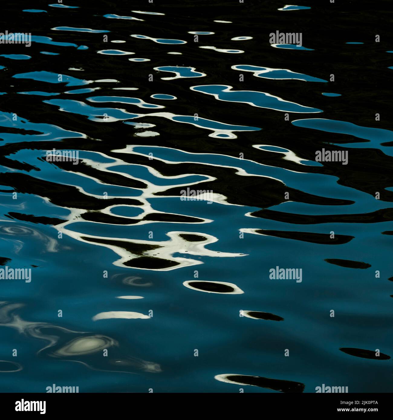 Closeup of s wavy water with the reflection of lunar path on it Stock Photo