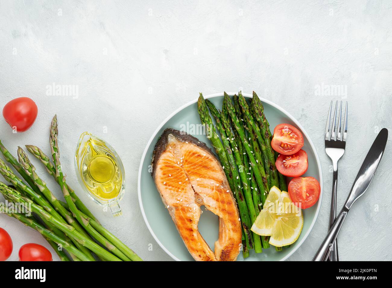 Grilled salmon steak and asparagus with ingredients on grey background. Top view, copy space Stock Photo