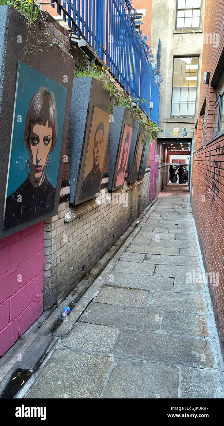 A vertical shot of a narrow street between buildings with painted ...