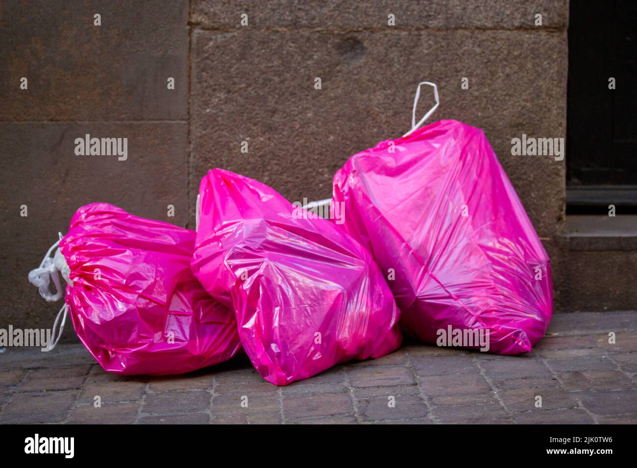 https://c8.alamy.com/comp/2JK0TW6/pile-of-pink-cellophane-garbage-bags-full-of-garbage-trash-lie-on-the-sidewalk-on-a-big-city-street-footpath-environmental-pollution-urban-ecology-p-2JK0TW6.jpg