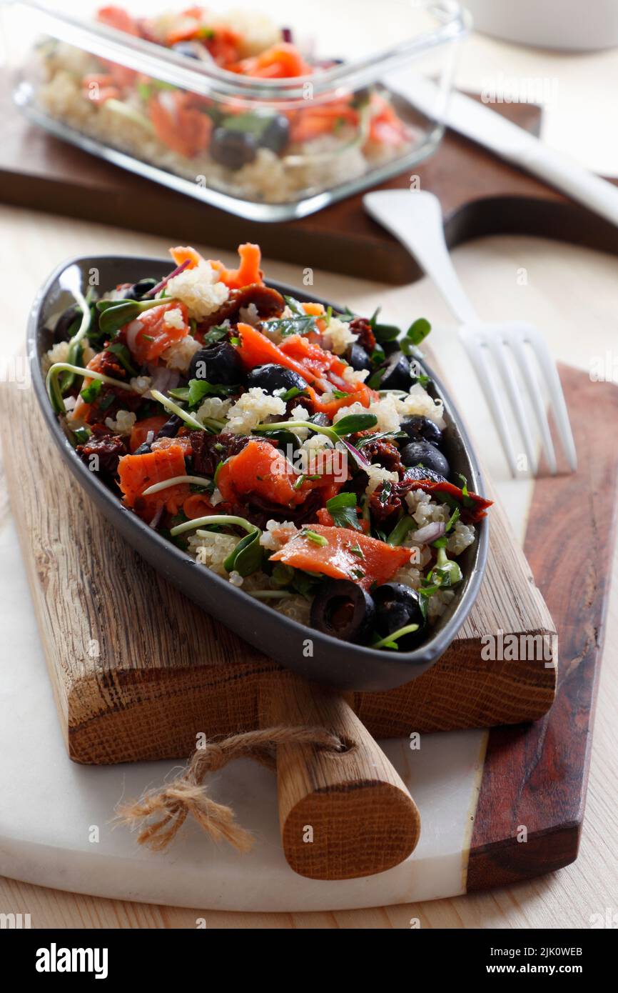 Salad with smoked wild salmon, quinoa sprouts, sun-dried tomatoes and olives Stock Photo