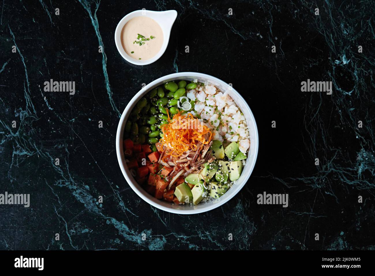 A healthy bowl with avocado, carrot, edamame and seafood Stock Photo