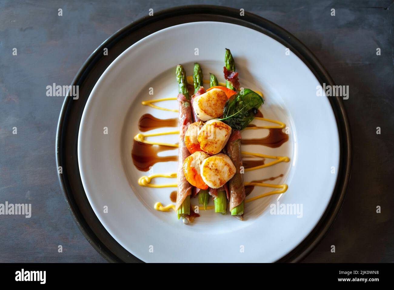 Scallops on asparagus wrapped in ham with balsamic vinegar and mayonnaise Stock Photo Alamy