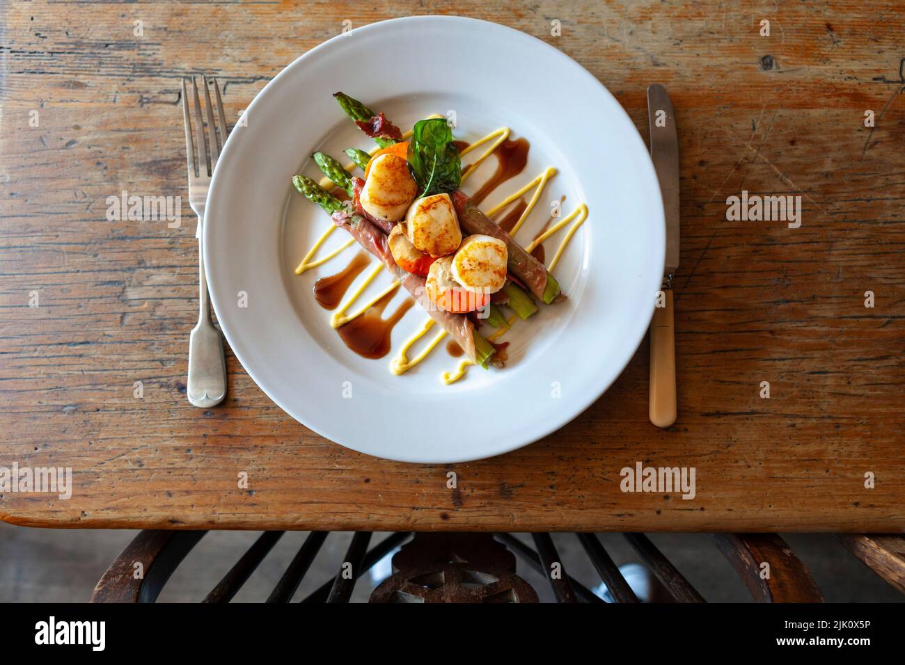 Scallops on asparagus wrapped in ham with balsamic vinegar and mayonnaise Stock Photo Alamy