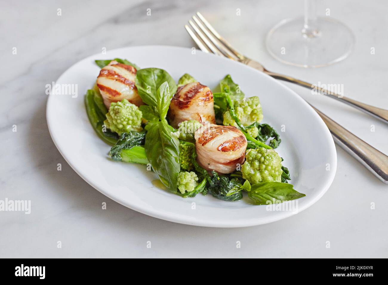 Scallops wrapped in parma ham on a green salad Stock Photo Alamy