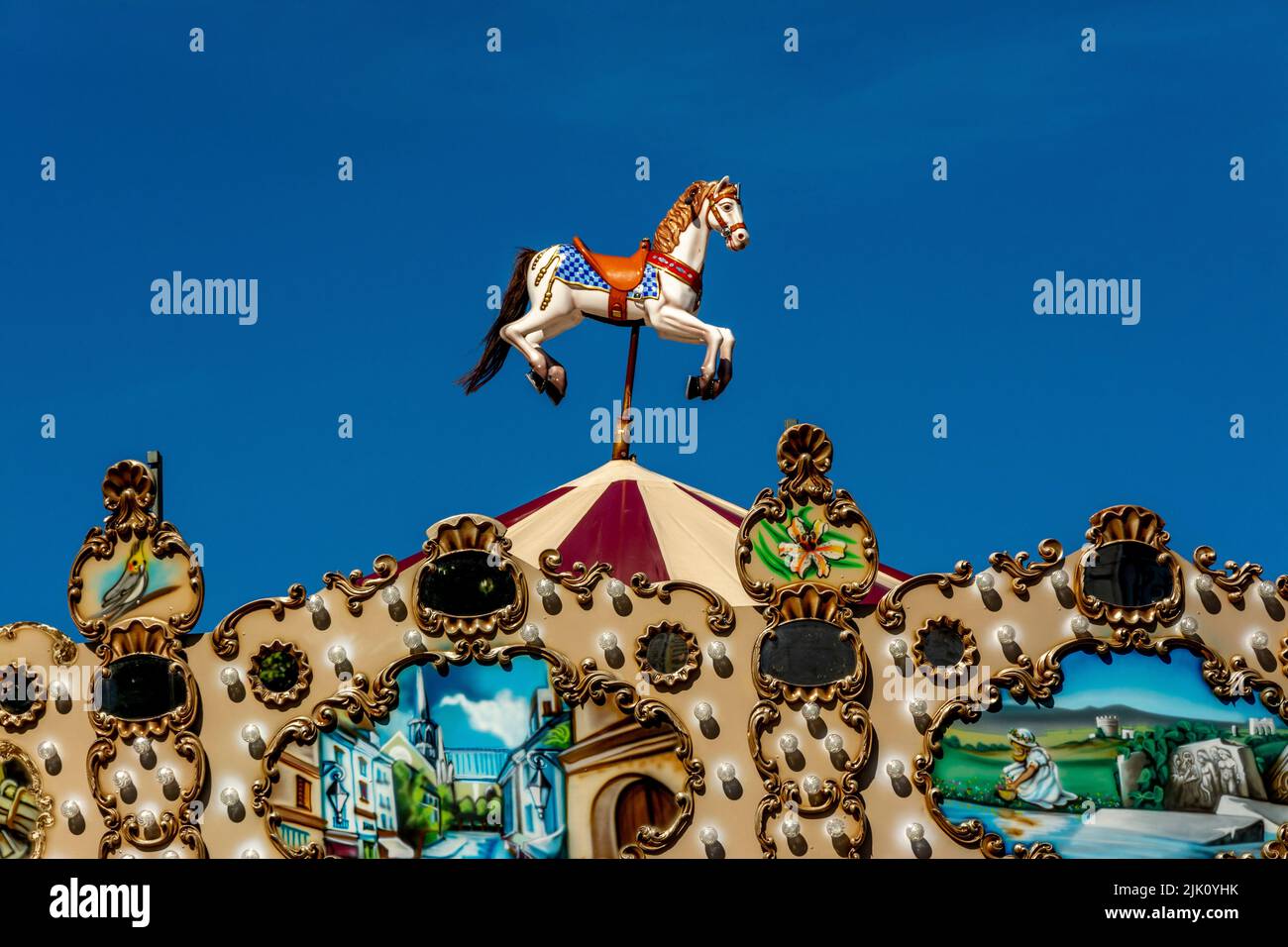 Close-up of a colorful carousel with a white cartoon horse Stock Photo
