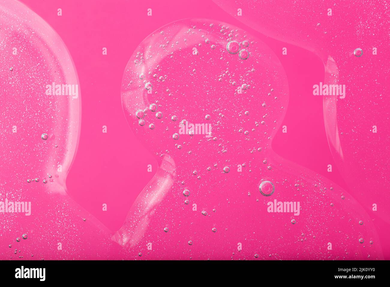 Top view of liquid cosmetics gel with bubbly structure on pink