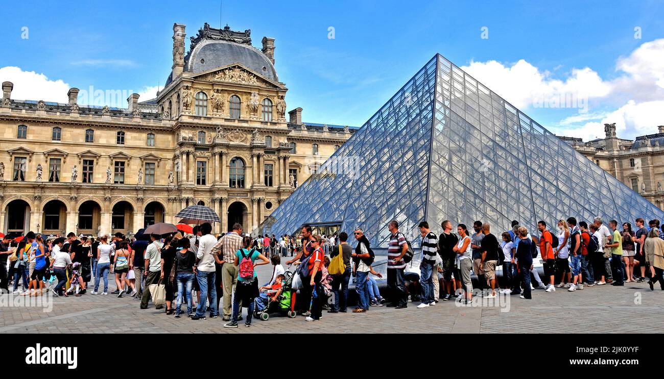 Tourists queue before the Pyranid of Louvre museum, Paris, France Stock Photo