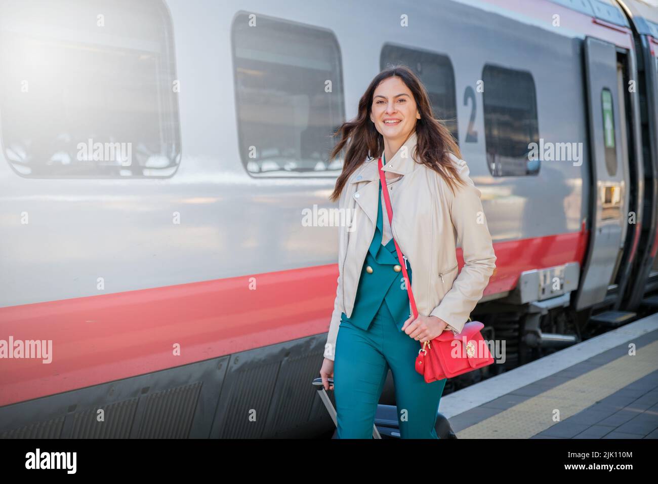 Portrait of a business woman commuter walking in a train station or airport going to boarding gate with hand luggage Stock Photo