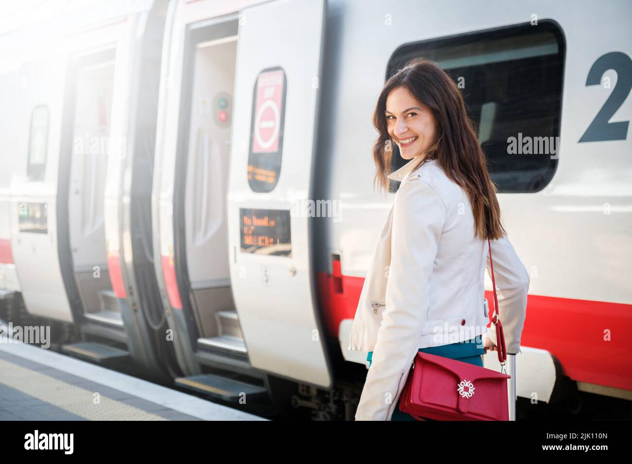 Portrait of a business woman commuter walking in a train station or airport going to boarding gate with hand luggage Stock Photo