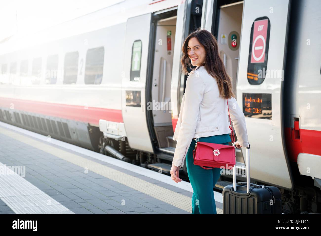 Portrait of a business woman commuter walking in a train station or airport going to boarding gate with hand luggage Stock Photo