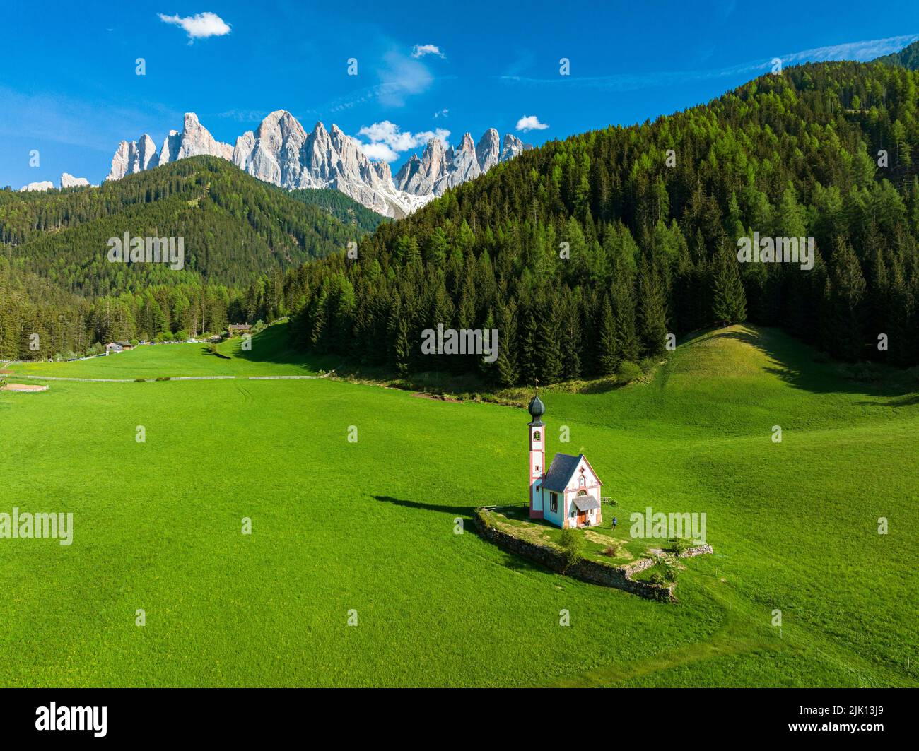 Aerial view of the Odle and iconic chapel of St. John in Ranui in spring, St. Magdalena, Funes Valley, Dolomites, South Tyrol, Italy, Europe Stock Photo