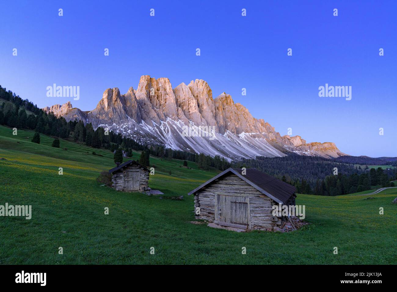 Sunrise over the Odle group and mountain huts in spring, Gampen Alm, Funes Valley, Dolomites, South Tyrol, Italy, Europe Stock Photo