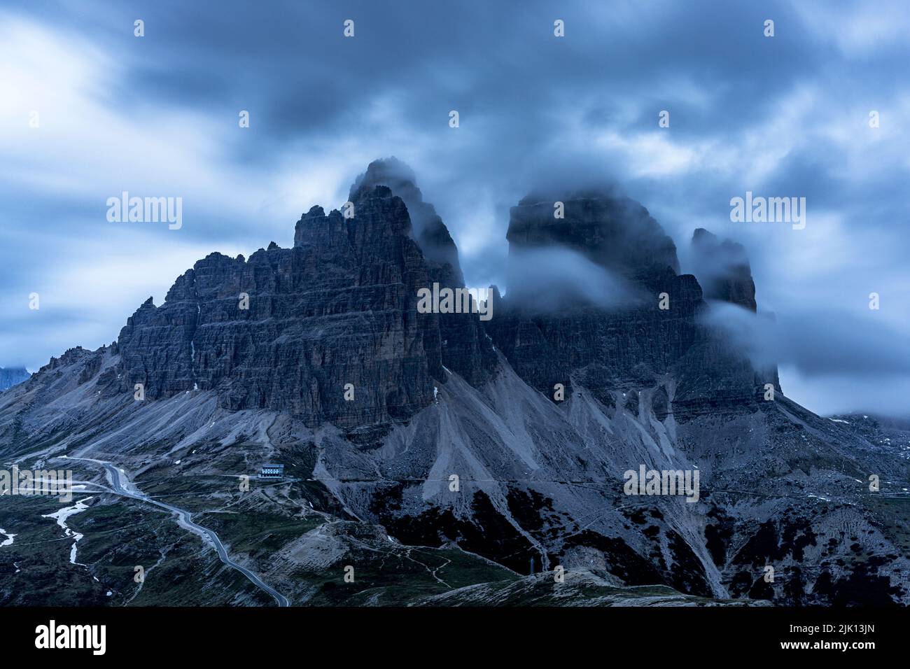 Clouds at dusk in the foggy sky over Tre Cime di Lavaredo mountain peaks, Dolomites, South Tyrol, Italy, Europe Stock Photo