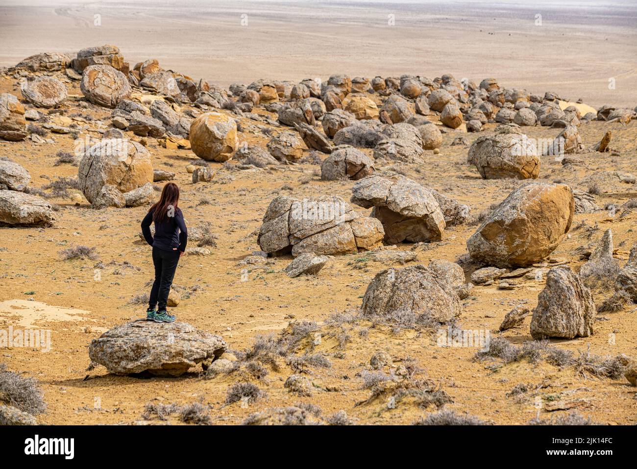 Woman standing in the Torysh (The Valley of Balls), Shetpe, Mangystau, Kazakhstan, Central Asia, Asia Stock Photo