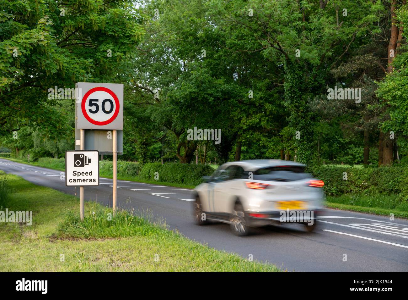 Vehicle travelling towards 50mph and speed camera signs on a Cheshire road, Cheshire, England, United Kingdom, Europe Stock Photo