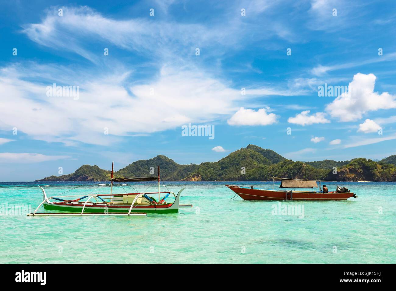 Outrigger canoe and tour boat off Mahoro Island, Pahepa Island beyond, Mahoro, Siau, Sangihe Archipelago, North Sulawesi, Indonesia Stock Photo
