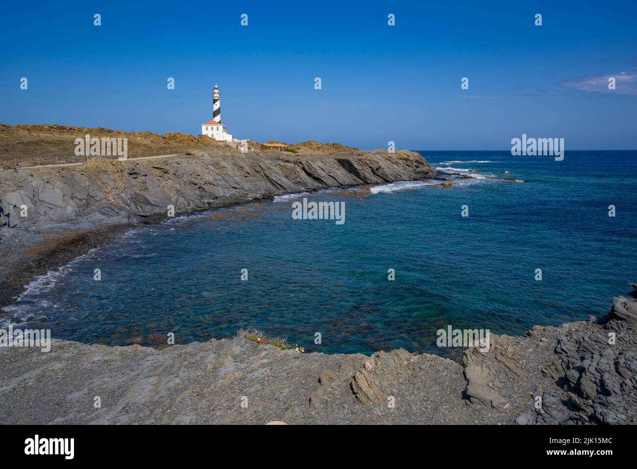 View of Far de Favaritx striped lighthouse on rocky headland, Carretera Favaritx, Menorca, Balearic Islands, Spain, Mediterranean, Europe Stock Photo