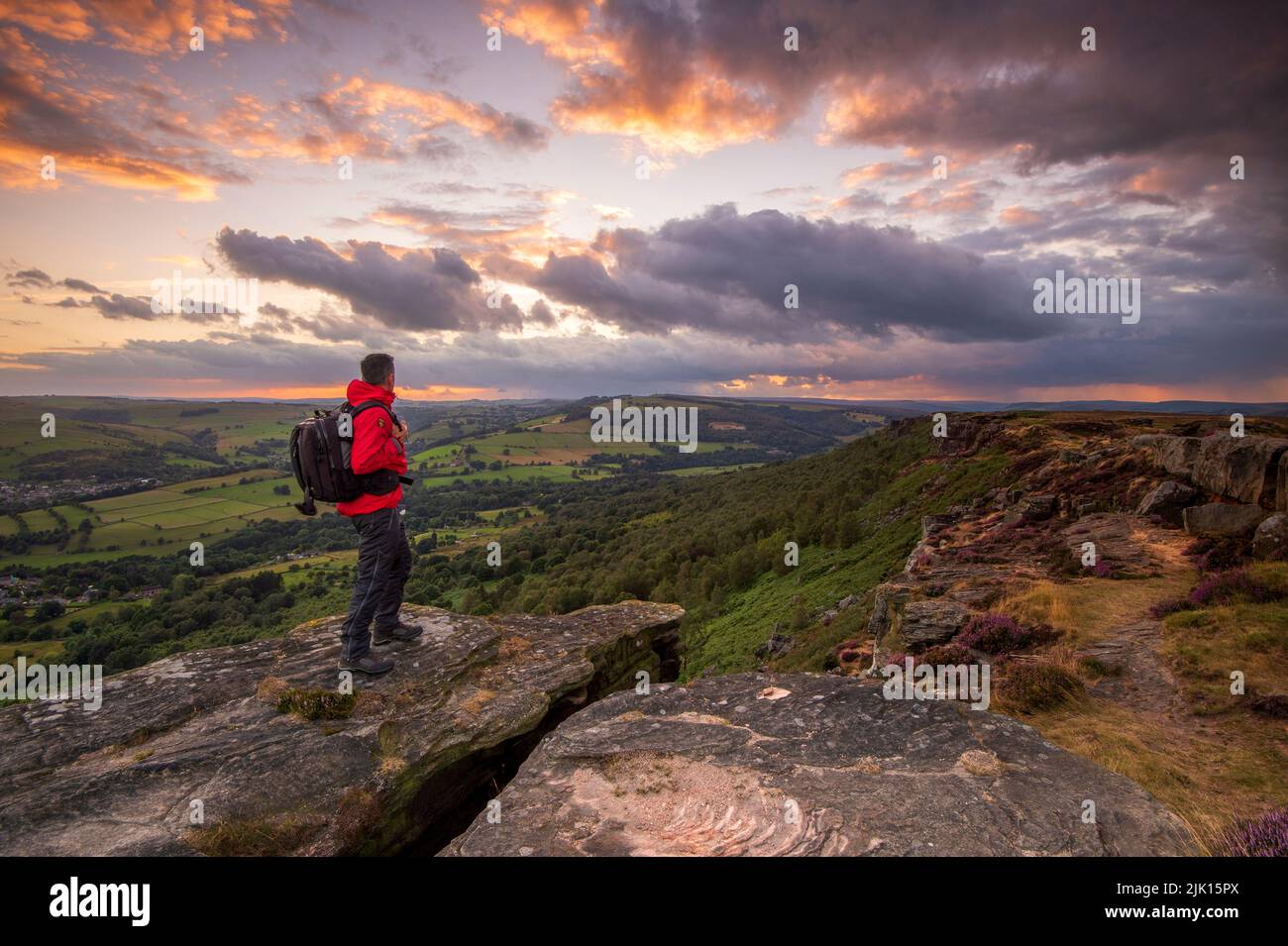 A male walker standing on Curbar Edge at sunset, Peak District, Derbyshire, England, United Kingdom, Europe Stock Photo