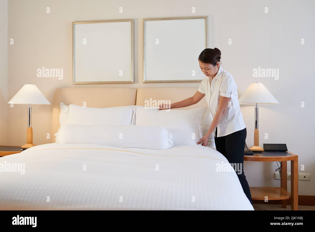 Maid changing linen in hotel room Stock Photo Alamy