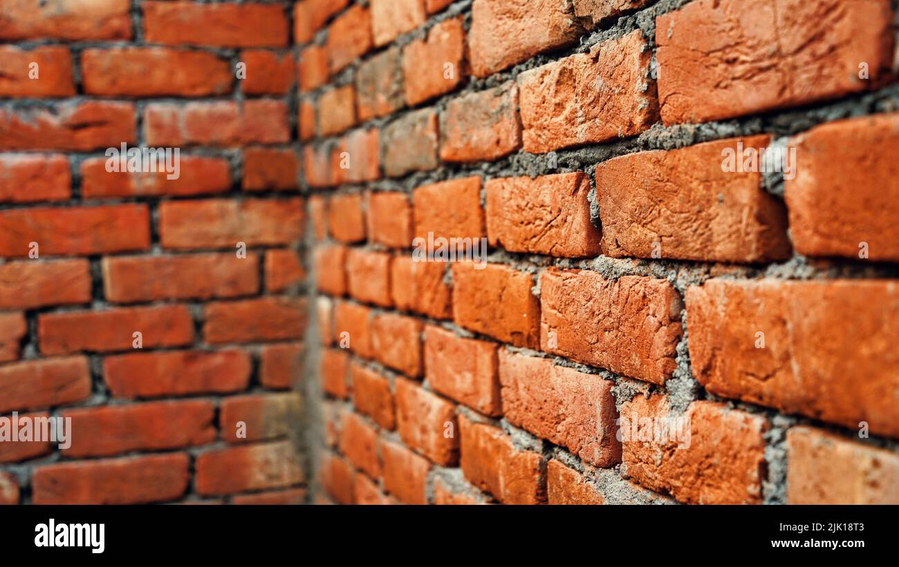 Brick wall under construction on nature background. Red Brick Wall With Diminishing Perspective. Fragment of brown brick wall with a shallow depth of Stock Photo