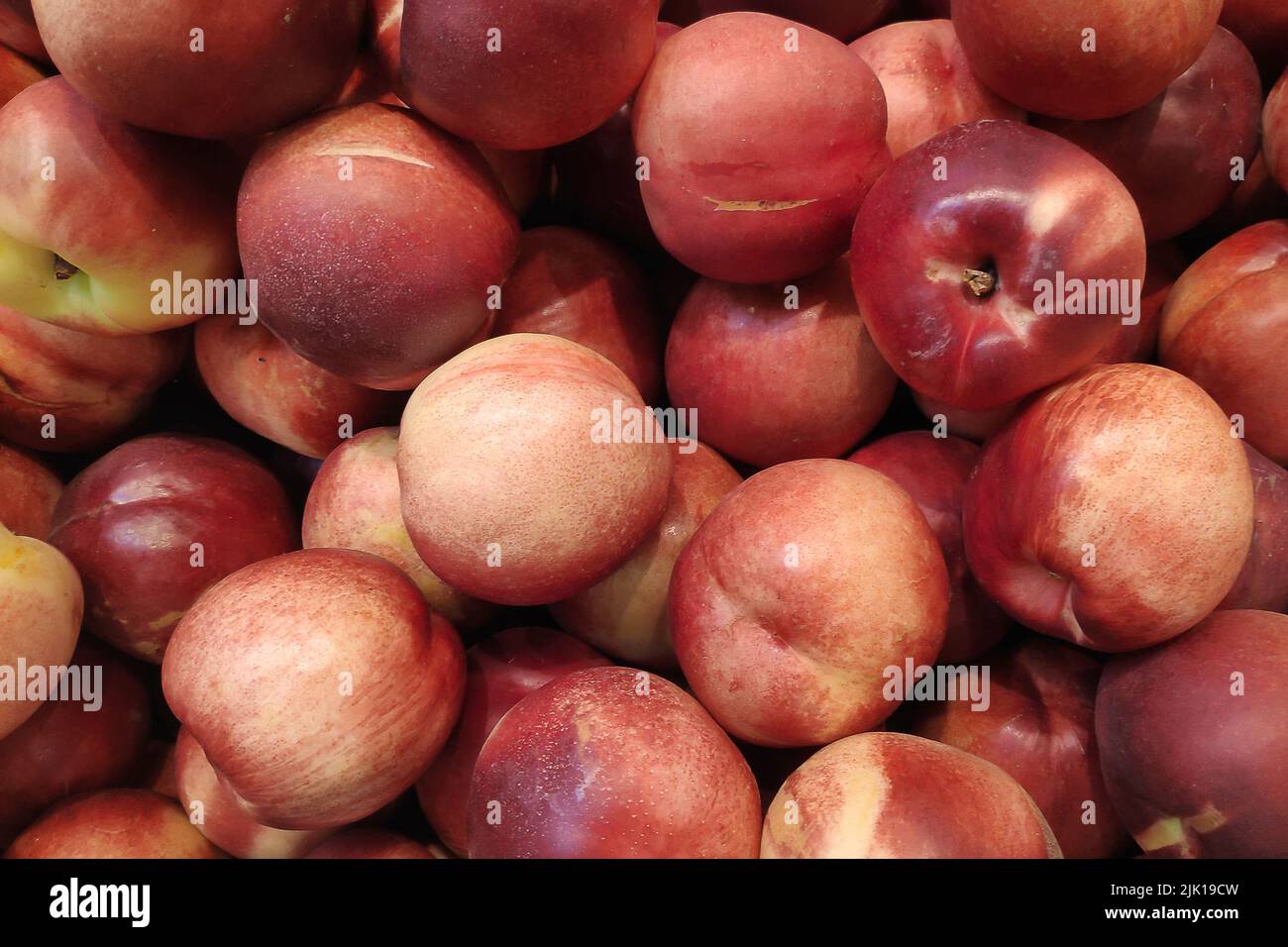 Stack of Nectarines (Prunus persica var. Nucipersica) on a market stall. Stock Photo