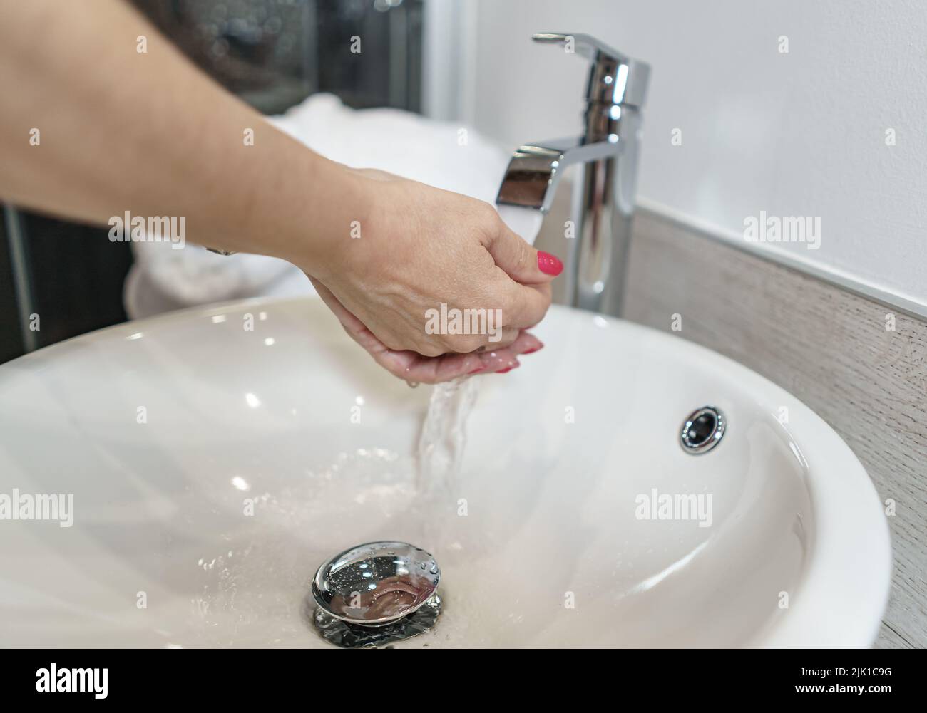 Woman washing her hands in a hotel bathroom. Spain. Stock Photo