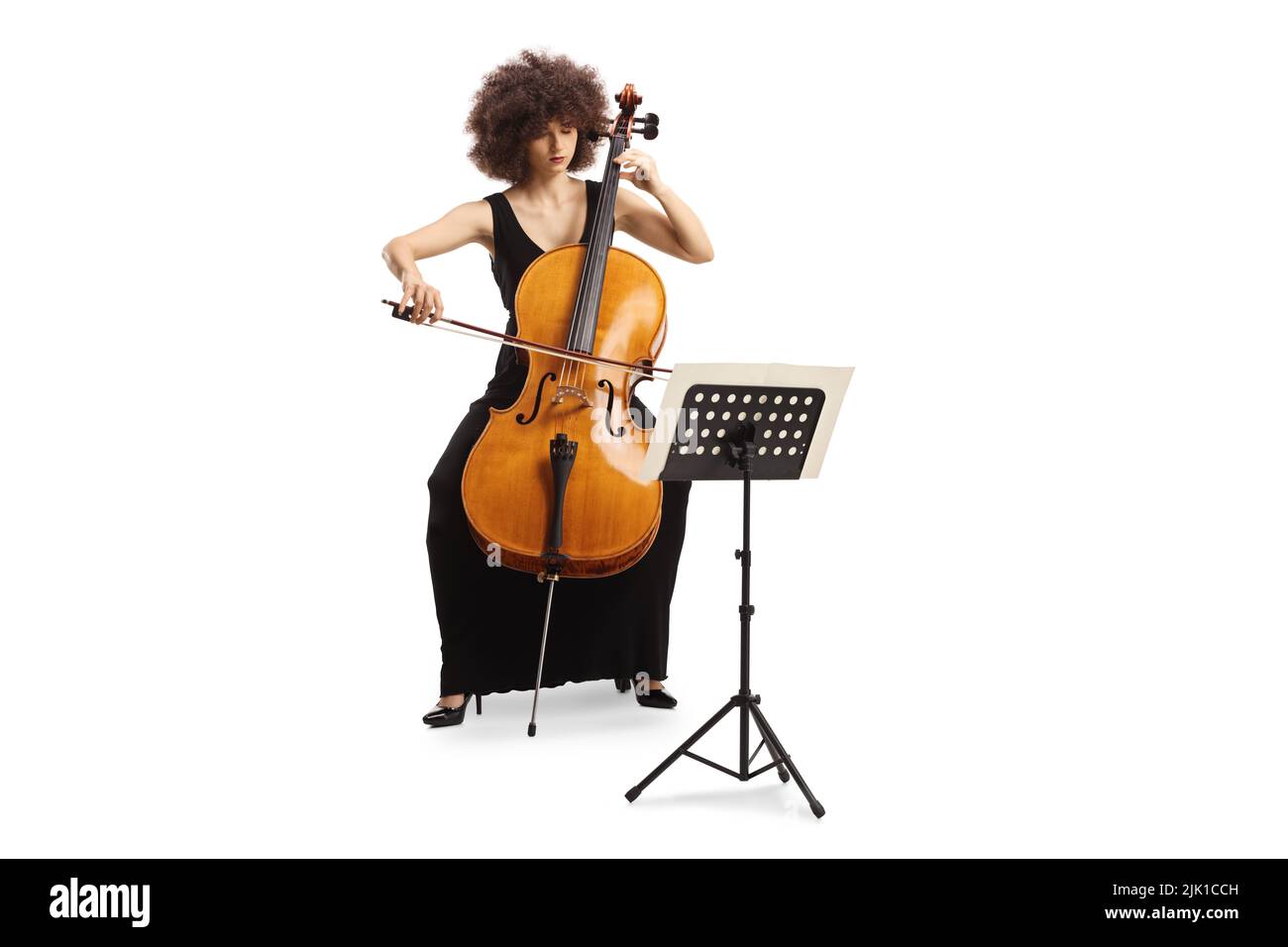 Young woman in a black dress playing cello and reading from a music ...