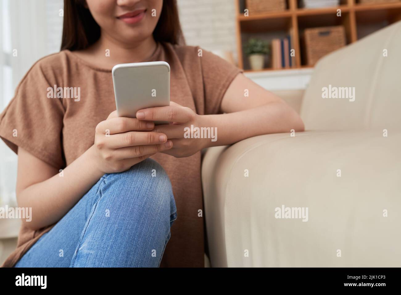 Cropped image of young woman using application on smartphone Stock Photo