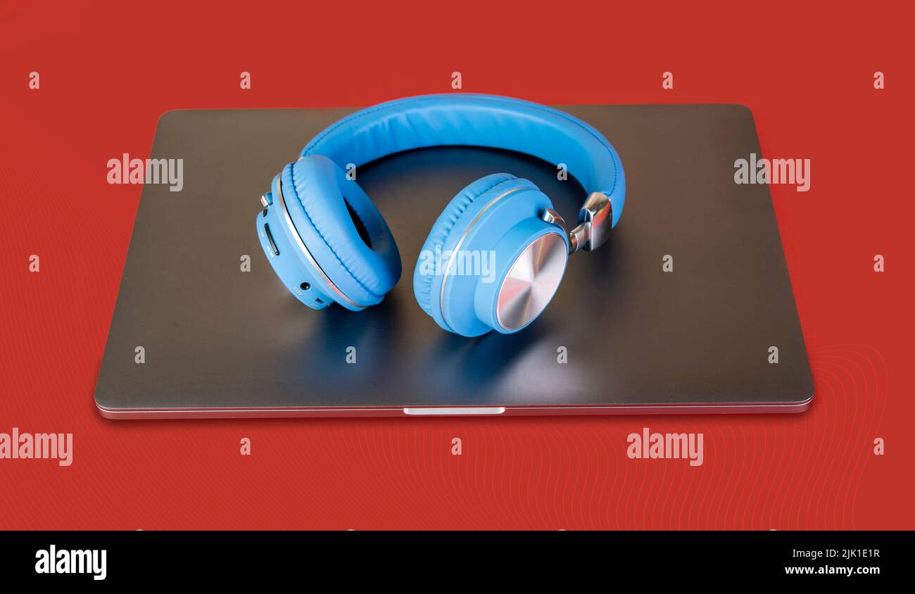 Blue wireless head on laptop top - music concept. Stock Photo