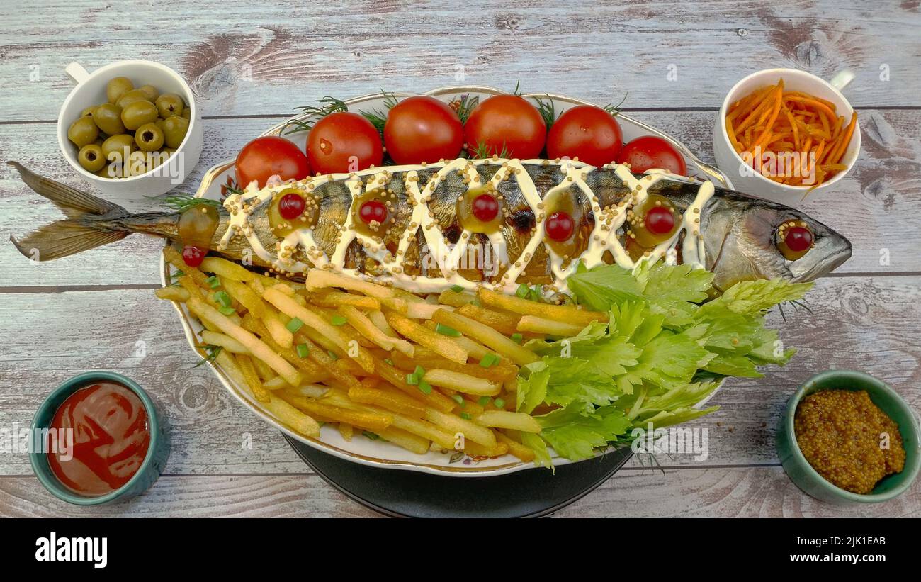 Fried mackerel fish with french fries, tomatoes and celery leaves