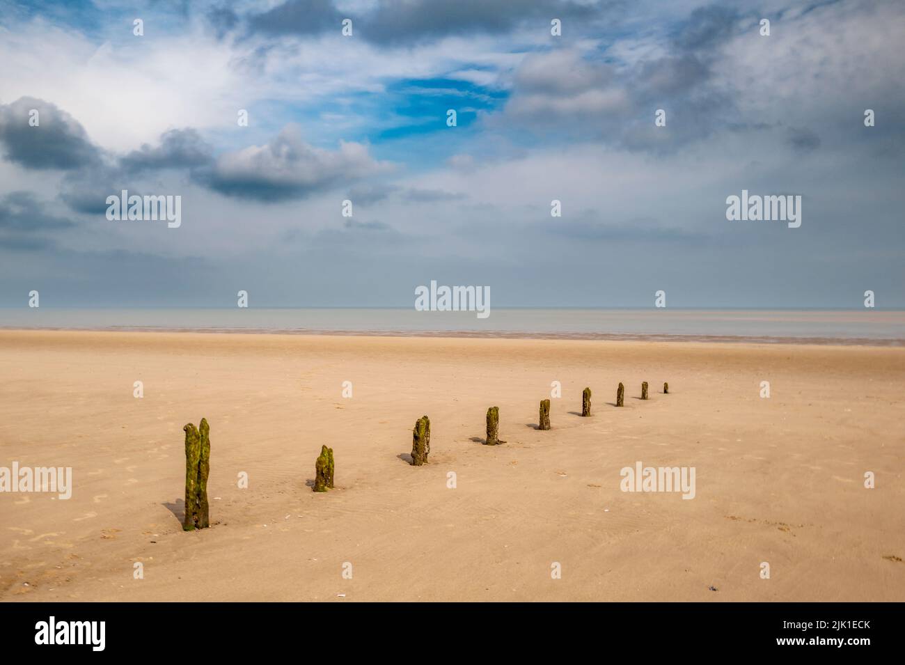A deserted Norfolk beach with the remains of a breakwater. Stock Photo