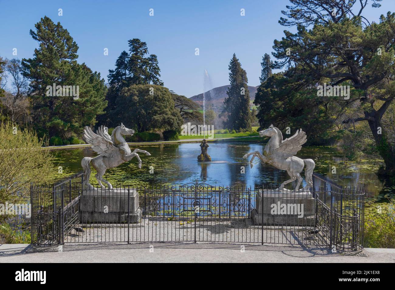 Ireland, County Wicklow, Enniskerry, Powerscourt Estate House and Gardens, The Winged Horses at the Triton Lake with fountain shooting into the air in the background. Stock Photo