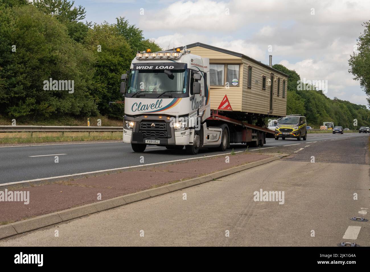 Clavell articulated lorry carrying wide load of a large caravan on the southern bypass norwich Norfolk Stock Photo