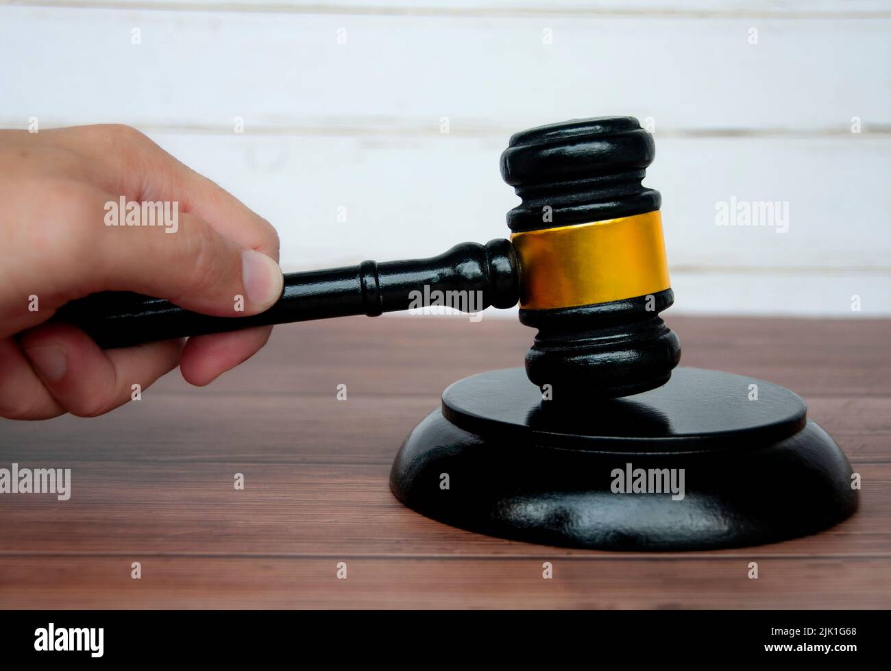 Hand holding lawyer gavel on wooden table background. Law and order concept Stock Photo