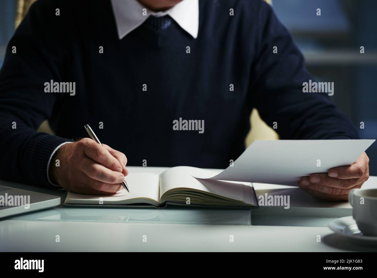 Cropped image of businessman reading documents and taking notes Stock Photo
