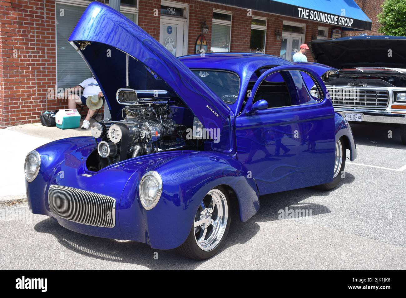 A Vintage Willys Restomod with a 454 Supercharged Engine on display at a car show. Stock Photo