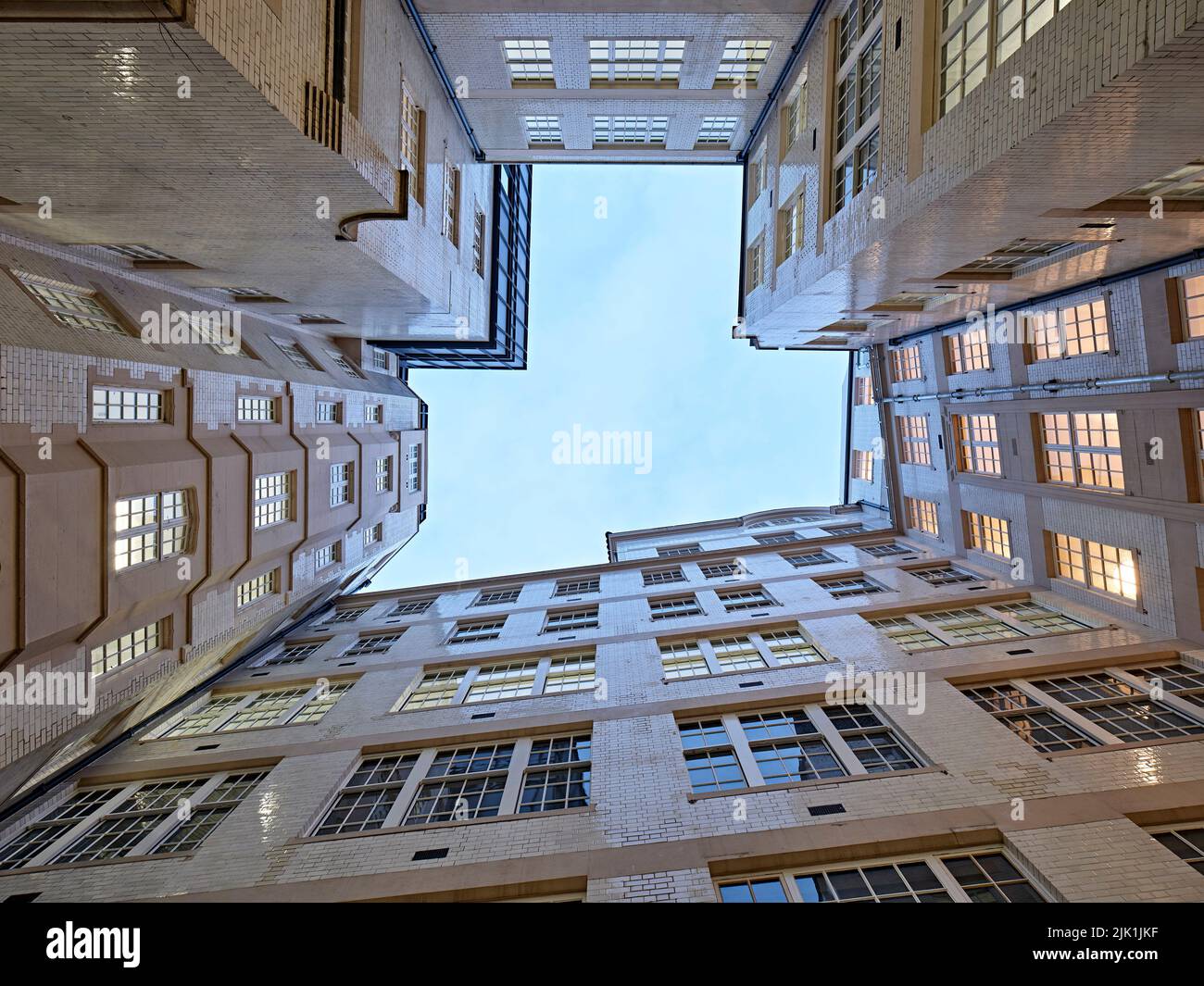 Extreme view upwards from open air courtyard with original facade. The Gilbert & One Lackington, London, United Kingdom. Architect: Stiff + Trevillion Stock Photo
