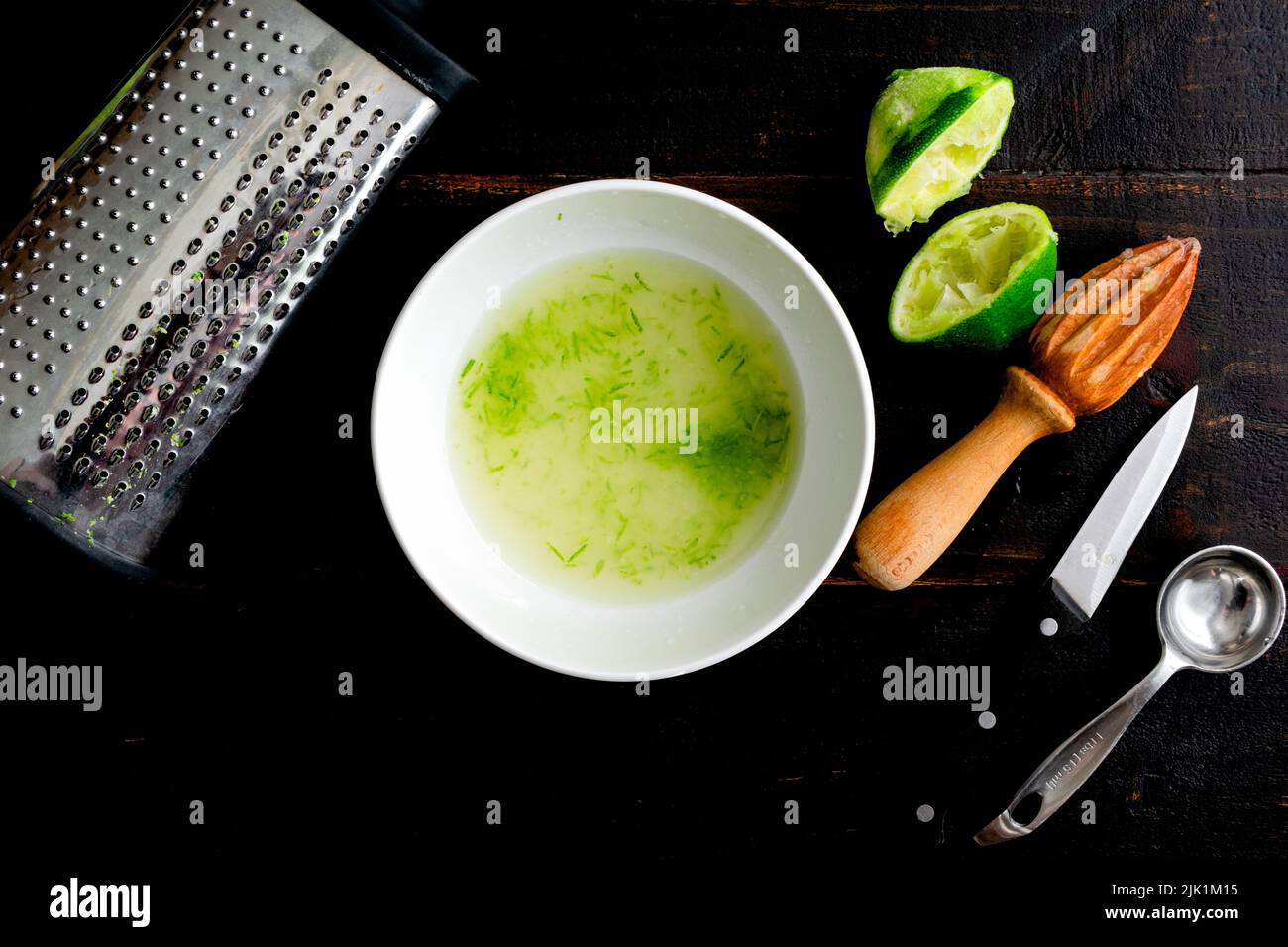 Making Lime Cordial on a Wood Tabletop Mixing simple syrup with lime