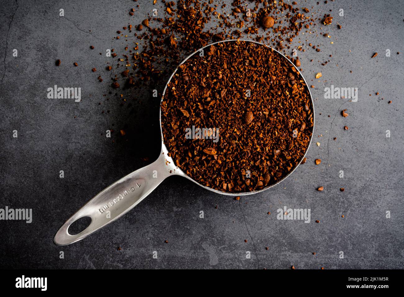 Coarsely Ground Coffee in a Measuring Cup Freshly ground coffee overflowing a measuring cup
