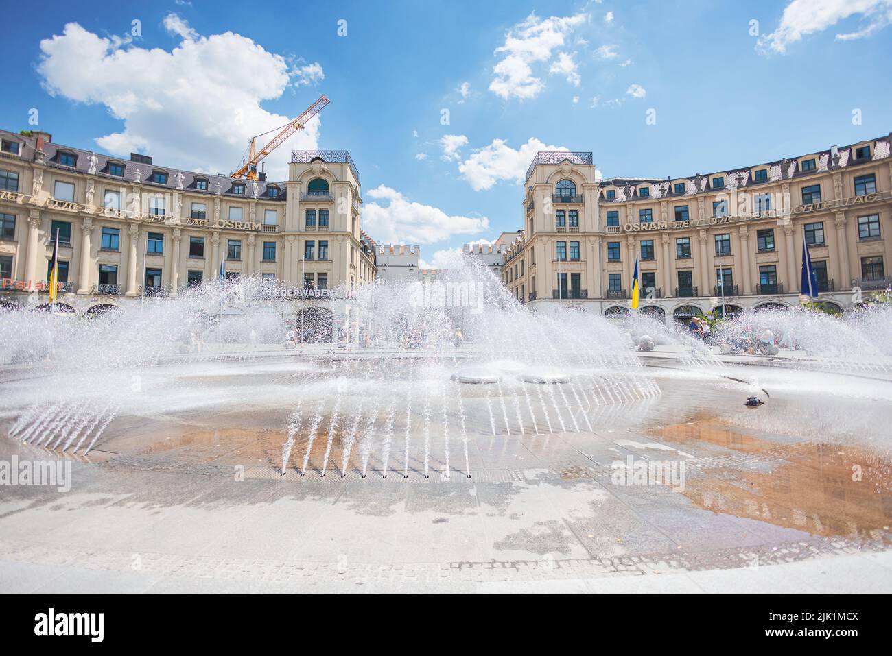 Munich, Germany - July 6, 2022: The Stachus or Karlsplatz in the center of Munich, with its opulent water features. View of the Karlstor through the f Stock Photo