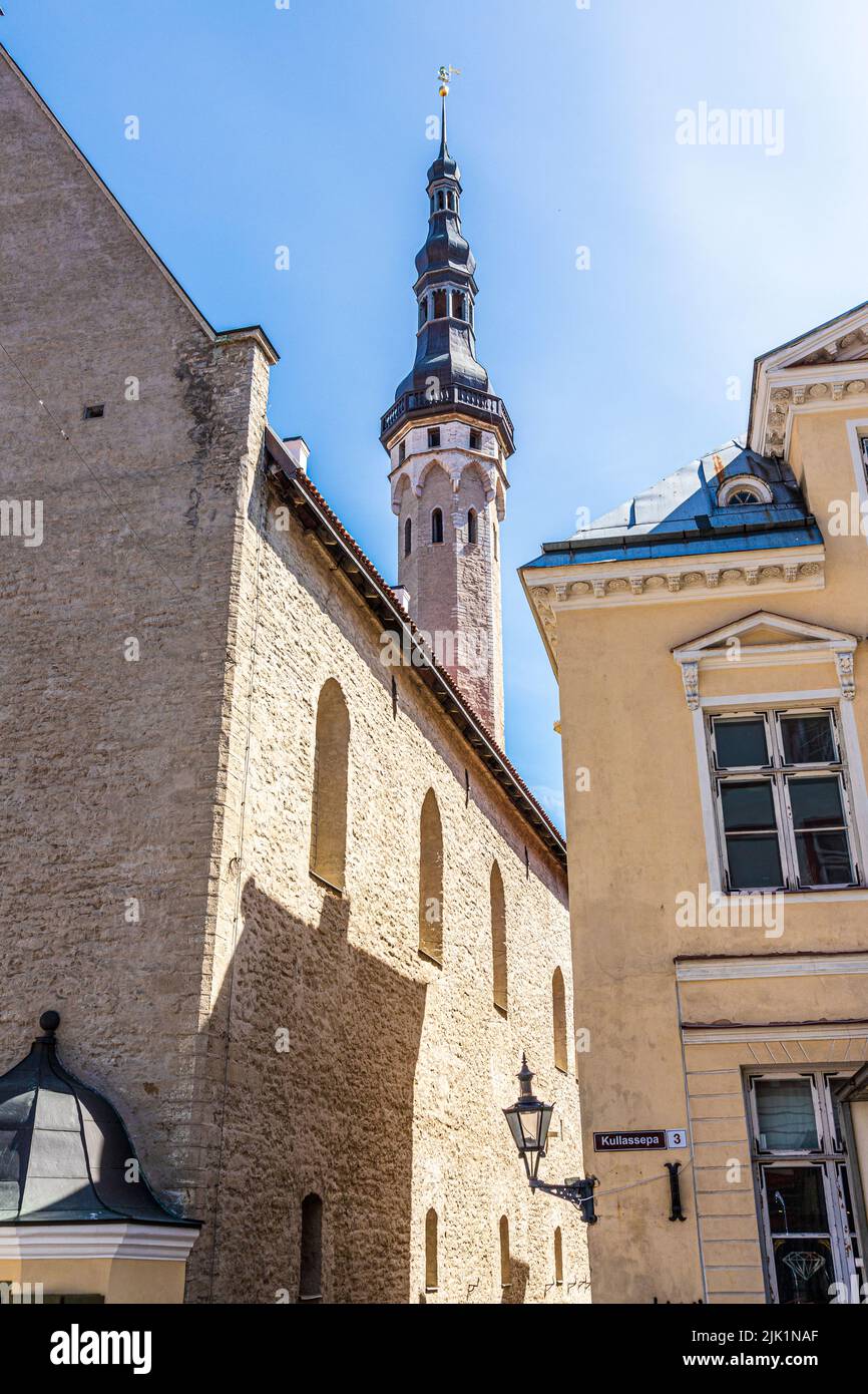 The Gothic tower and spire of the Town Hall (Tallinna raekoda) overlooking buildings in the square in the Old Town of Tallinn the capital city of Esto Stock Photo